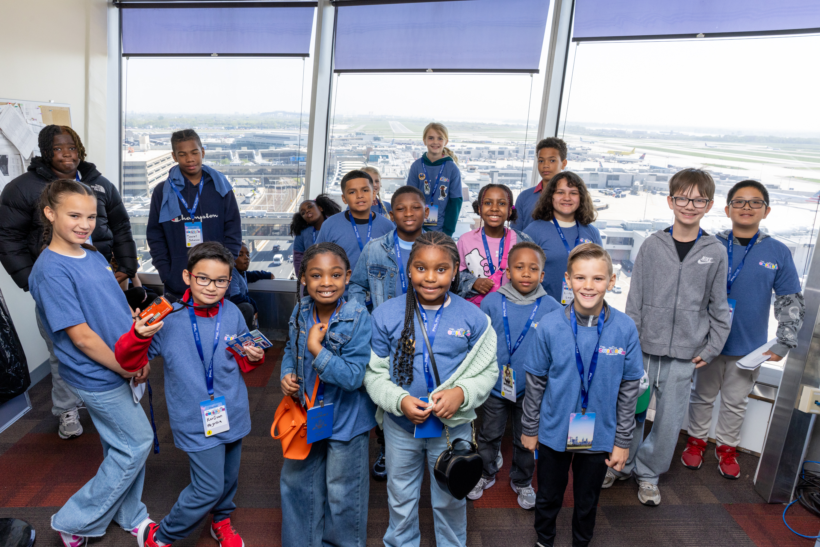 A group of young children visit PHL airport and view the airfield from the ramp tower