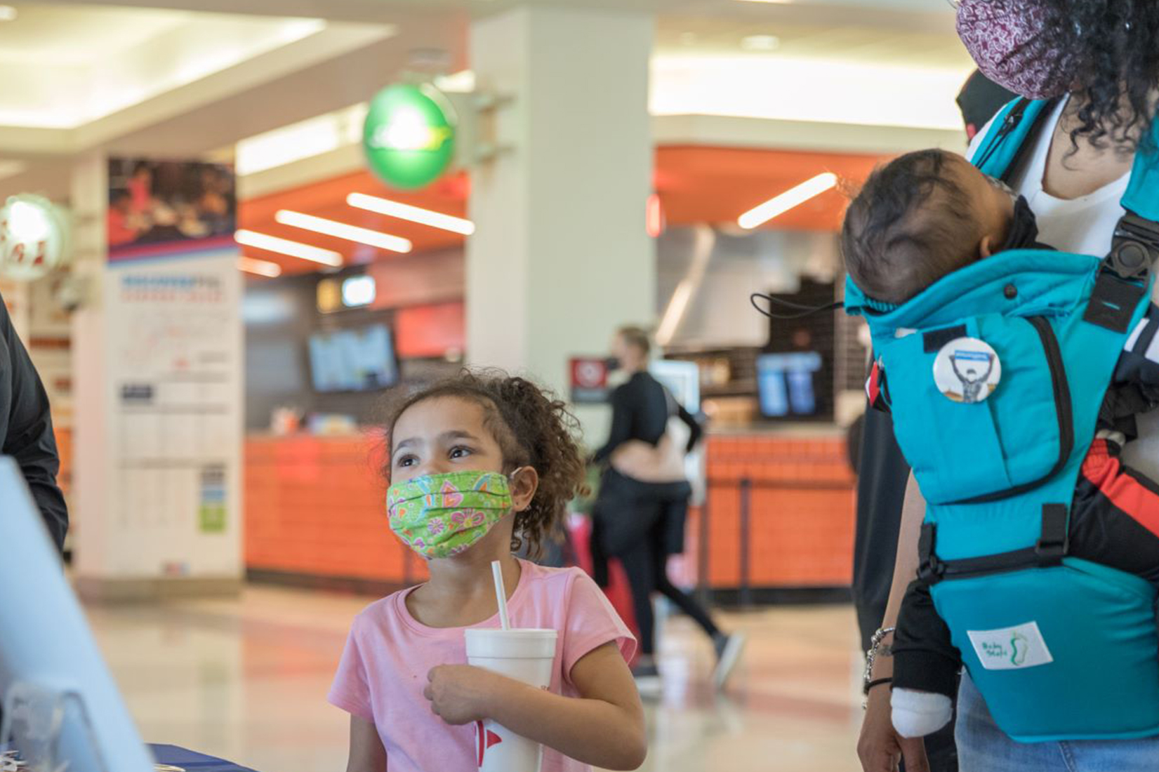 young child and baby with mother in airport