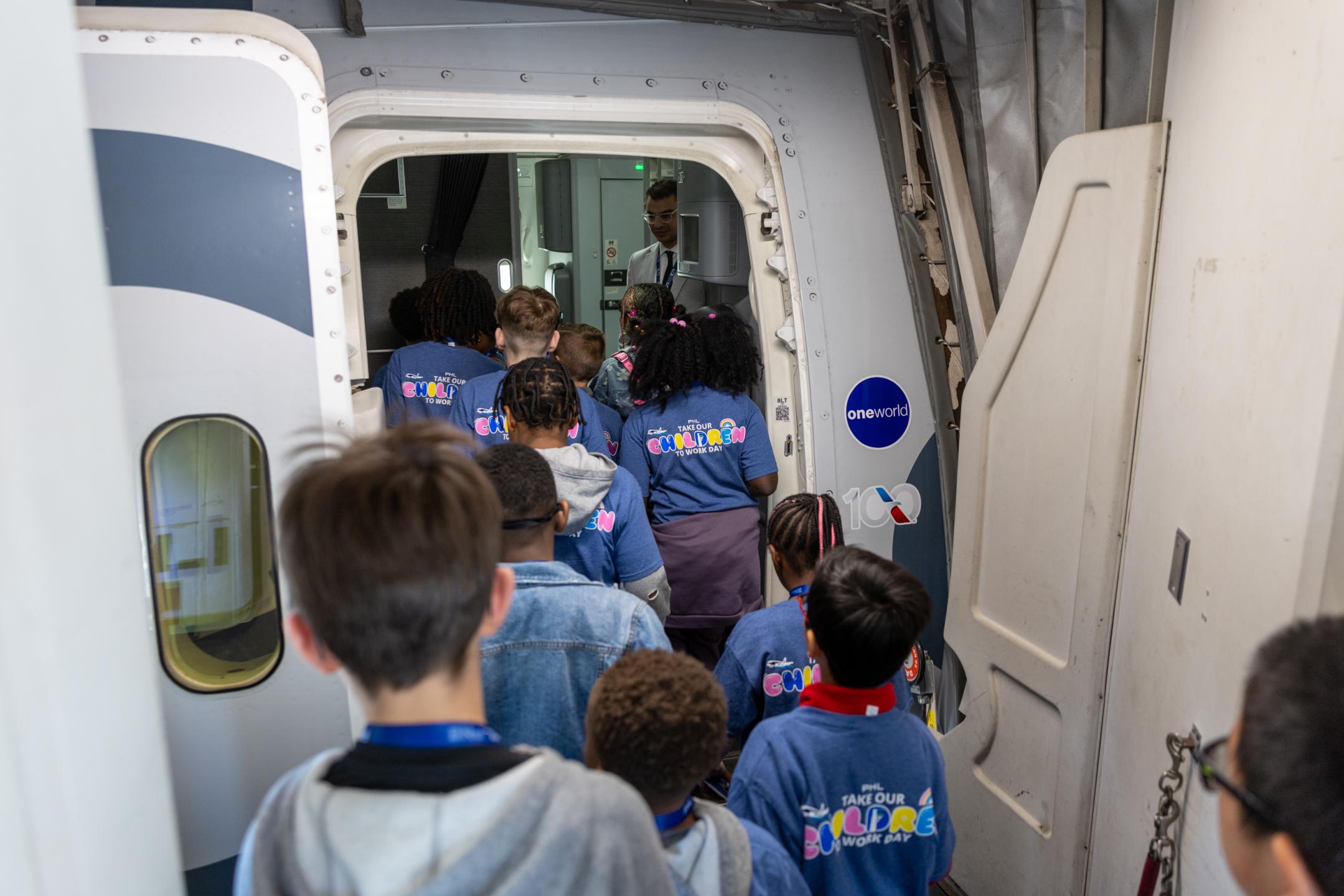 Children board an American Airlines plane at PHL. 