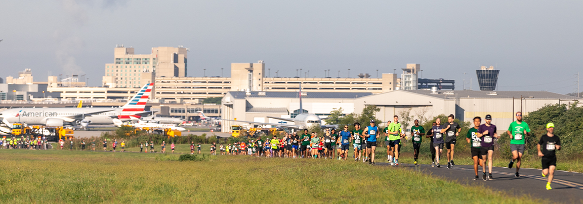 5k runners with airport in background 