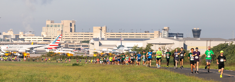 people running on the airport runway