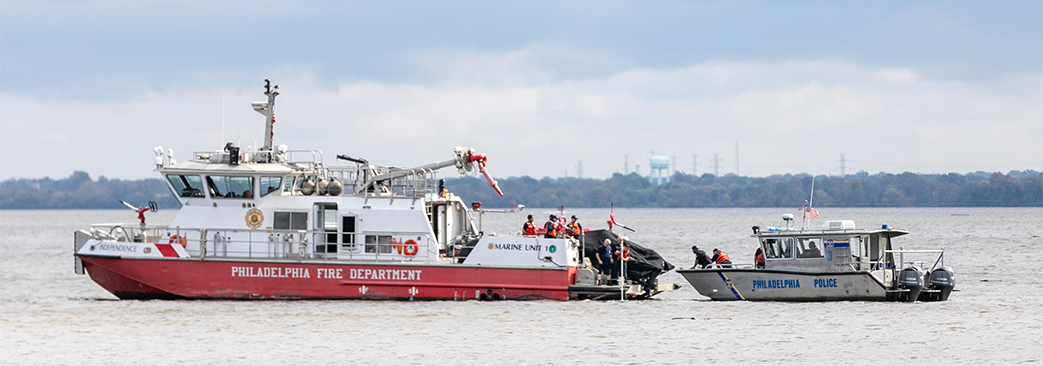 Police boat getting passengers off white and red boat