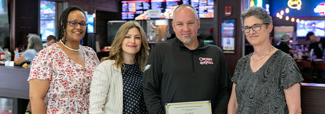 Paul Porter holding award with guest experience team