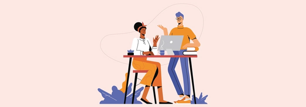 two young professionals at a desk looking at computer