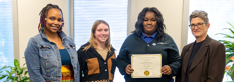 Alycia holding award with employee engagement team 