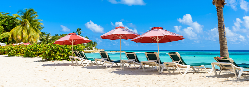 chairs in the sand at a beach in barbados