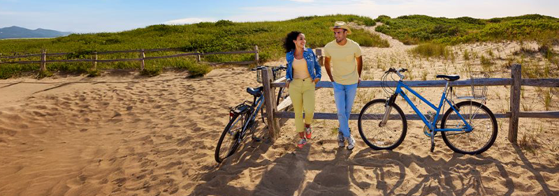 man and woman in n sand with bikes next to them
