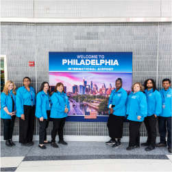 customer care team in front of welcome to Philadelphia sign