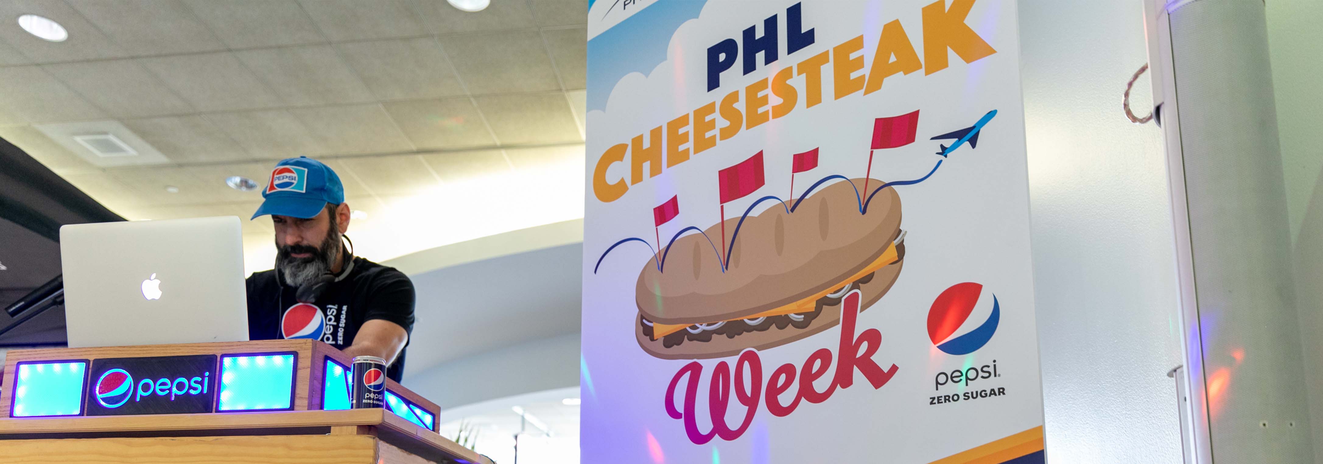 PHL Cheesesteak week sign with DJ with Pepsi gear on