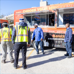 employees standing around talking next to a food truck