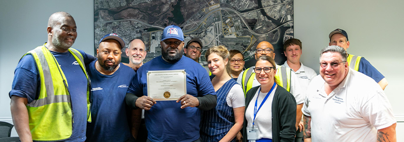 James with co workers holding award
