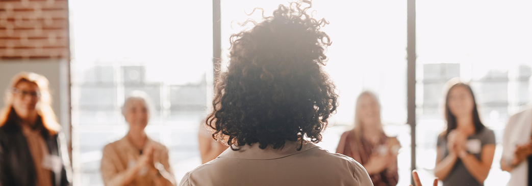 woman talking to a group of professionals