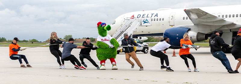 people and Phillies mascot pulling plane