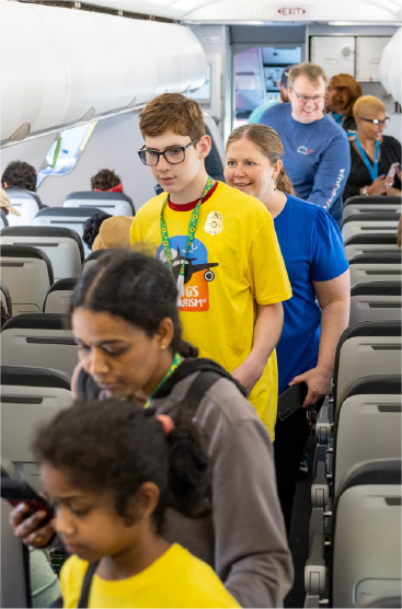 children and parents walking down aisle of plane
