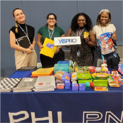 YoPros standing behind table to school supplies
