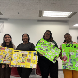 four people holding up 2026 vision boards